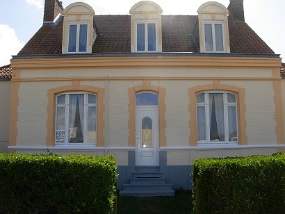 Façade de maison à Calais après ravalement, teinte sable et encadrements ocre