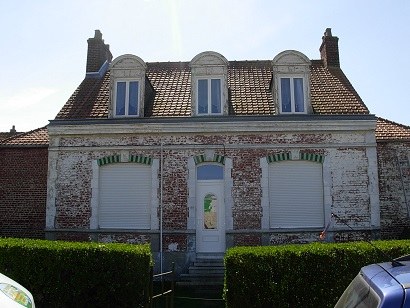 Maison à Calais avant ravalement, façade dégradée par plaques laissant la brique apparente par endroits