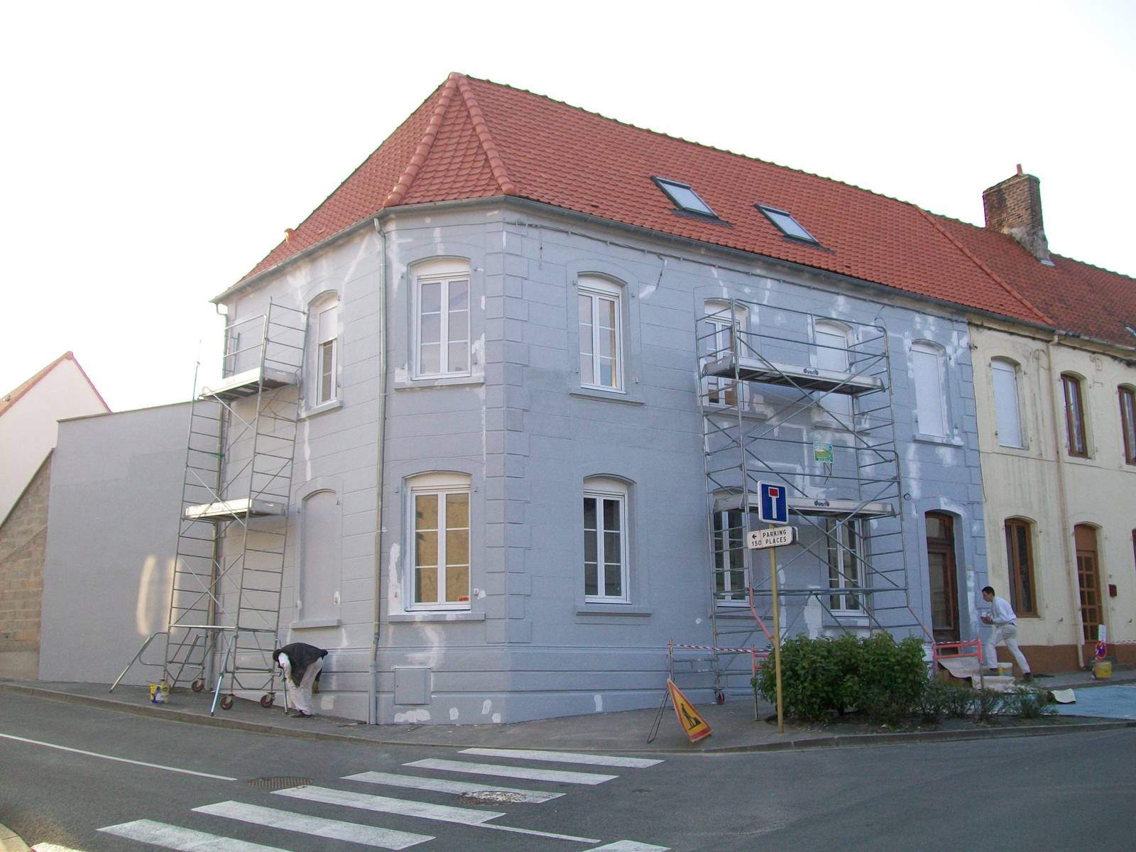 Ravalement de façade en cours à Samer, application de la teinte bleu-gris depuis l'échafaudage