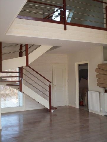 Escalier en bois et rampe repeints dans une cage d'escalier